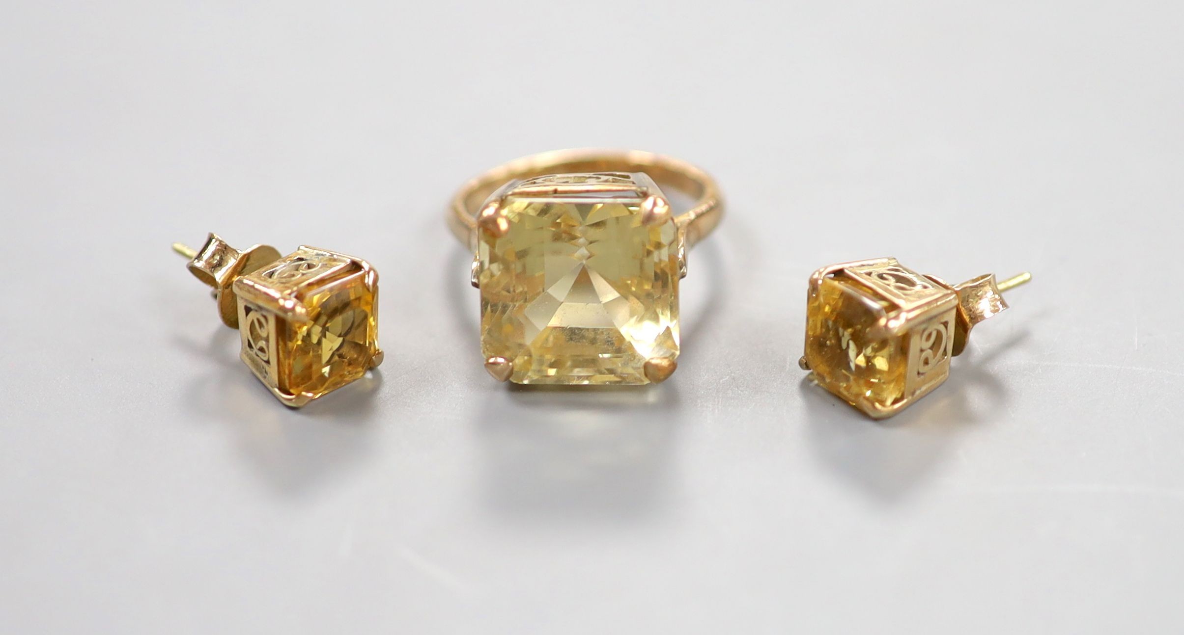 A yellow metal and citrine set dress ring, size K and a pair of similar ear studs, gross weight 10 grams.